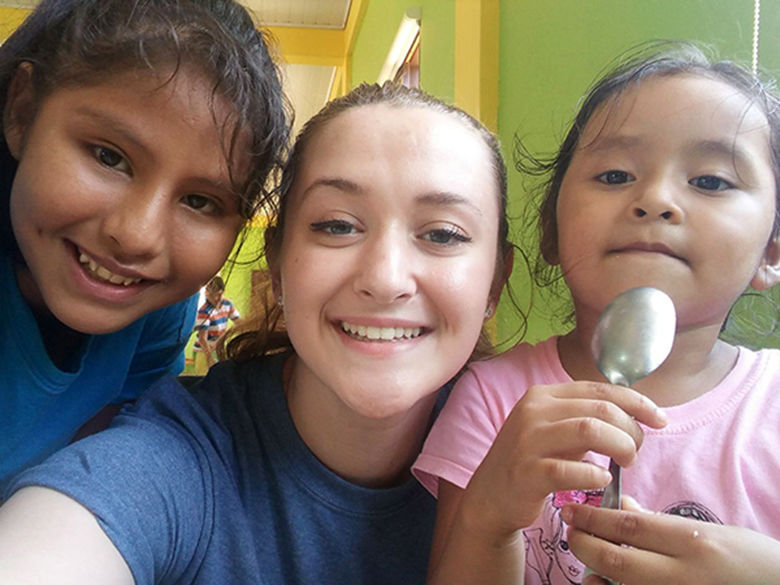 A Penn State Altoona Enactus student with children in Bolivia