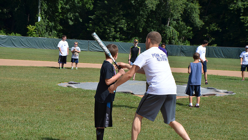 Students assist children in a game of baseball as part of the Voluntoona community service effort.